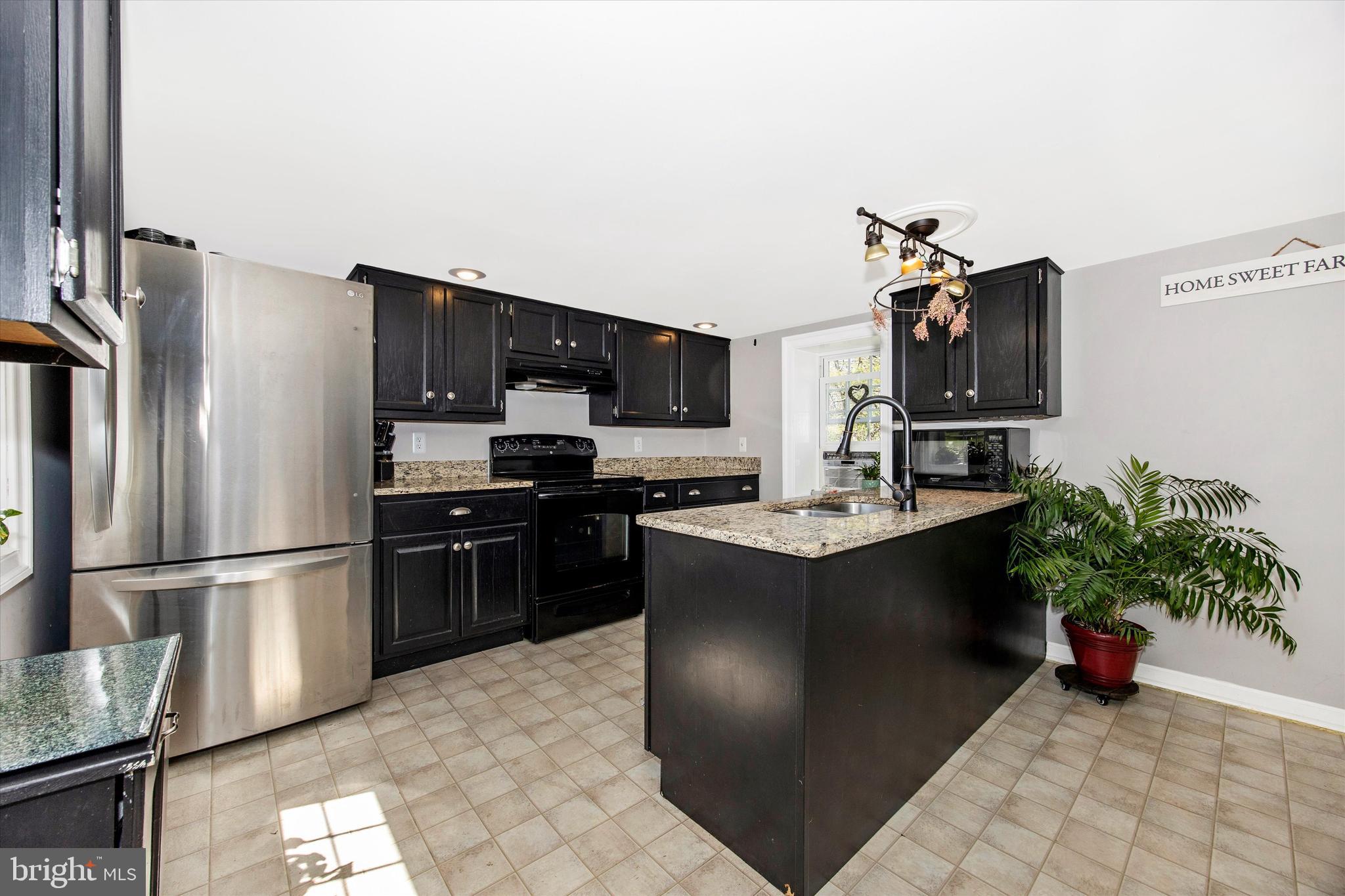 3204 Bidle Road Middletown, MD 21769 - Photo 6 of 23 a kitchen with stainless steel appliances kitchen island granite countertop a refrigerator and a stove top oven