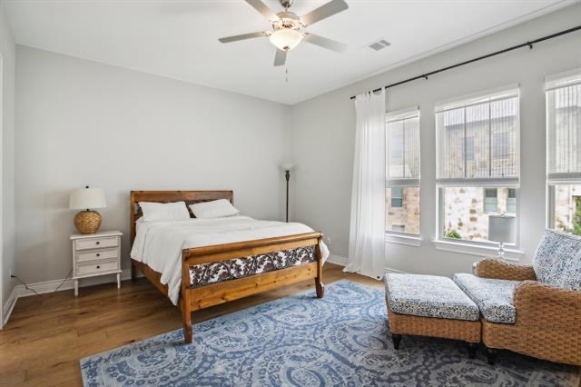 332 Adams Street Georgetown, TX 78628 - Photo 12 of 37 Well-lit sleeping quarters with rich hardwood flooring and a stylish ceiling fan offer a comfortable retreat.