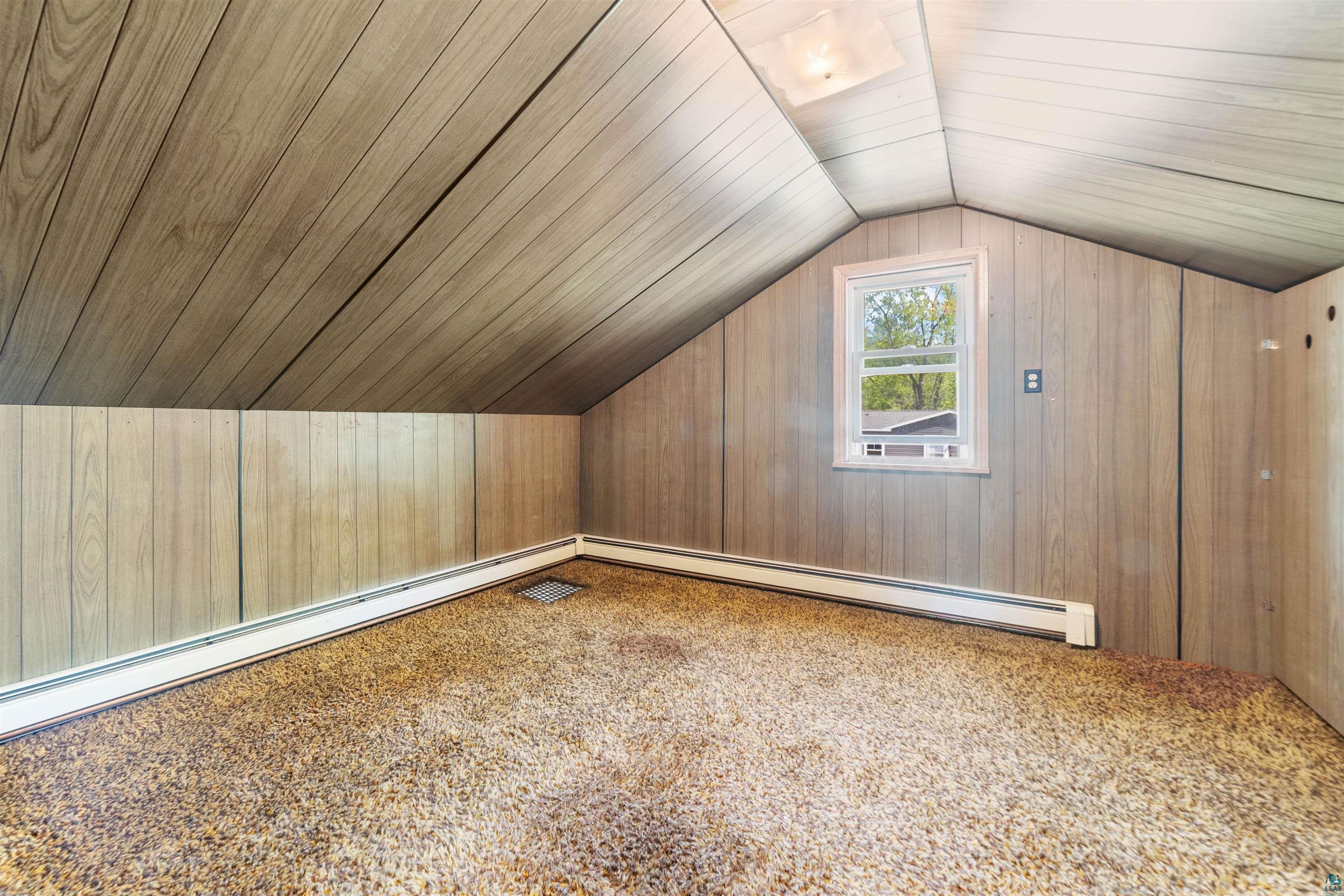 3469 County Road East South Range, WI 54874 - Photo 11 of 19 Bonus room featuring wooden walls, a baseboard heating unit, wood ceiling, and lofted ceiling