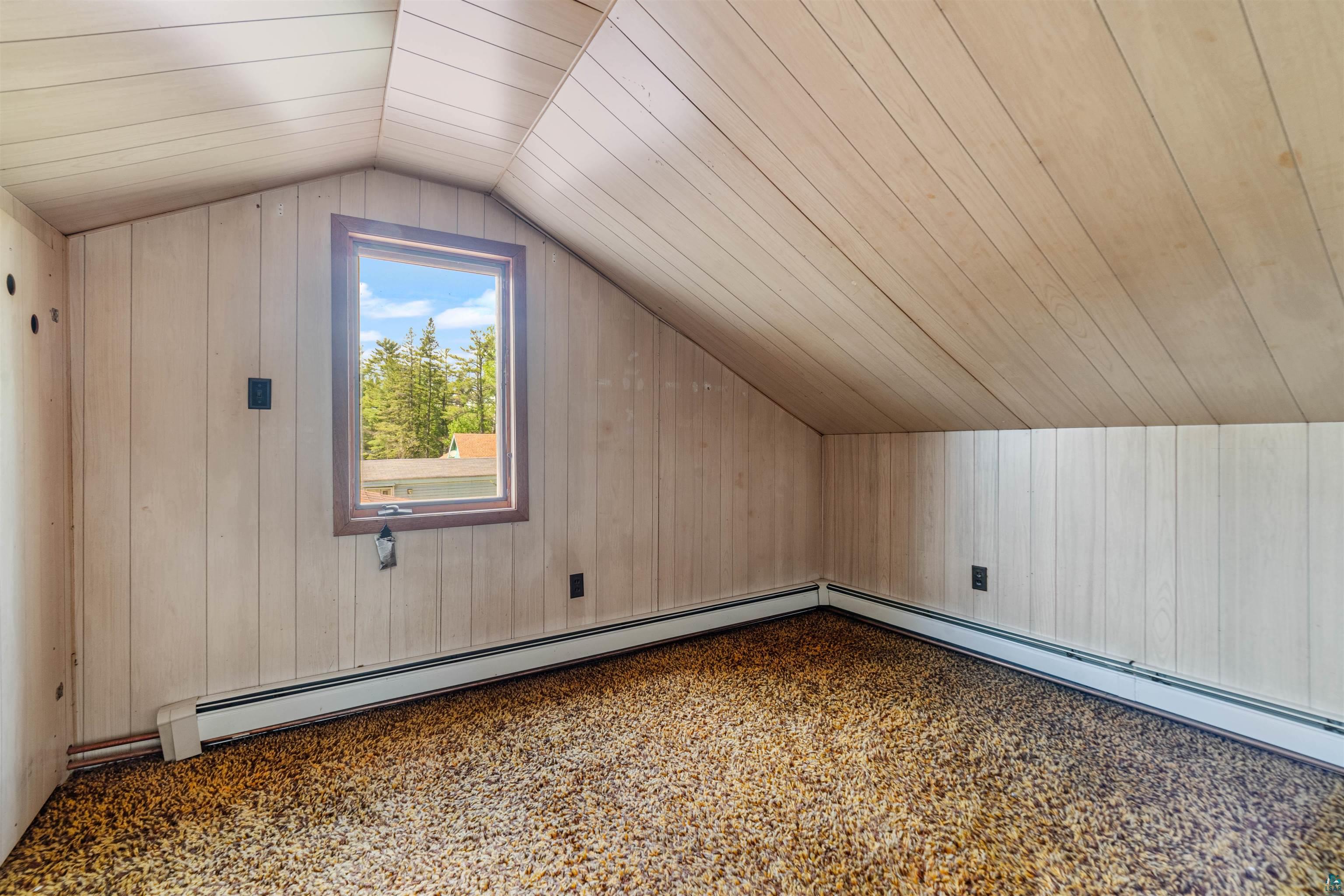 3469 County Road East South Range, WI 54874 - Photo 12 of 19 Additional living space with carpet floors, a baseboard radiator, lofted ceiling, and wood ceiling