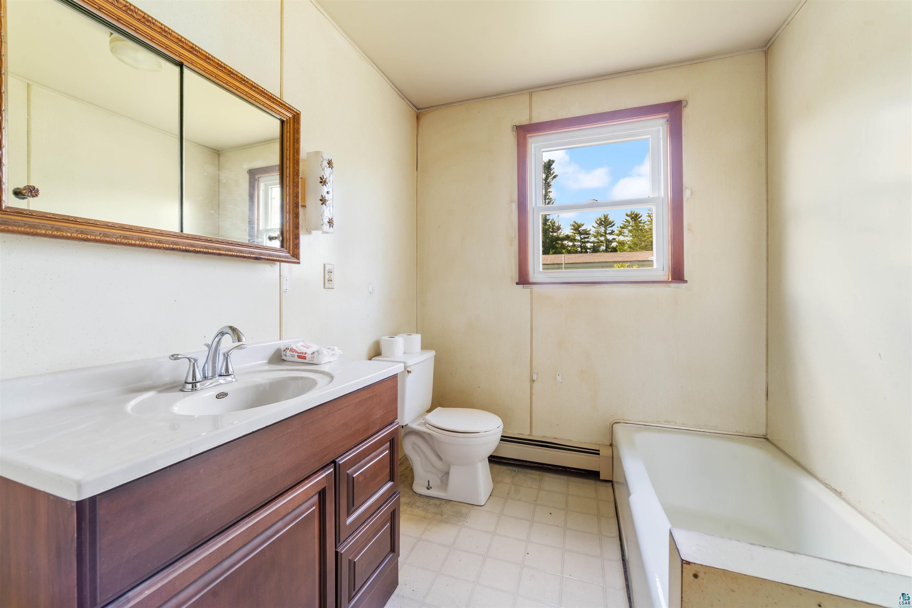 3469 County Road East South Range, WI 54874 - Photo 8 of 19 Bathroom featuring a baseboard radiator, tile flooring, a tub, large vanity, and toilet