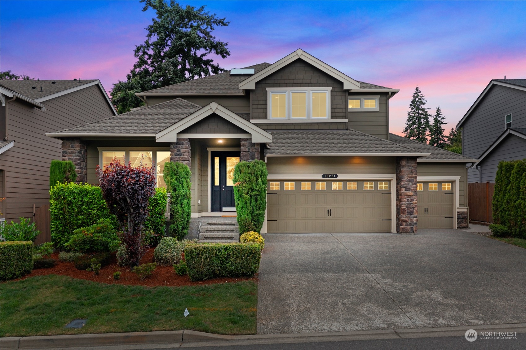 a front view of a house with a yard and garage