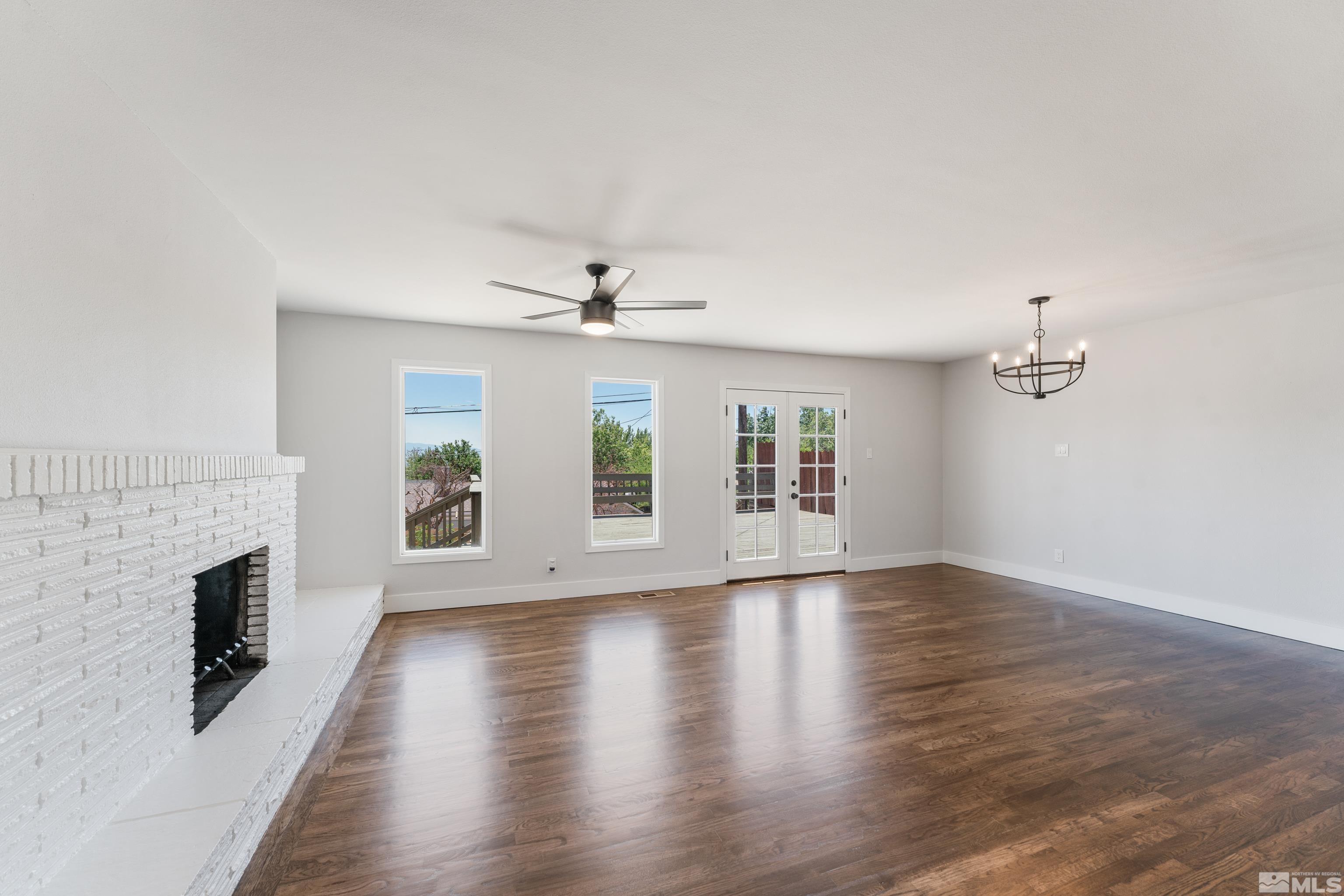 3380 Bryan Street Reno, NV 89503 - Photo 12 of 40 an empty room with wooden floor fireplace and windows