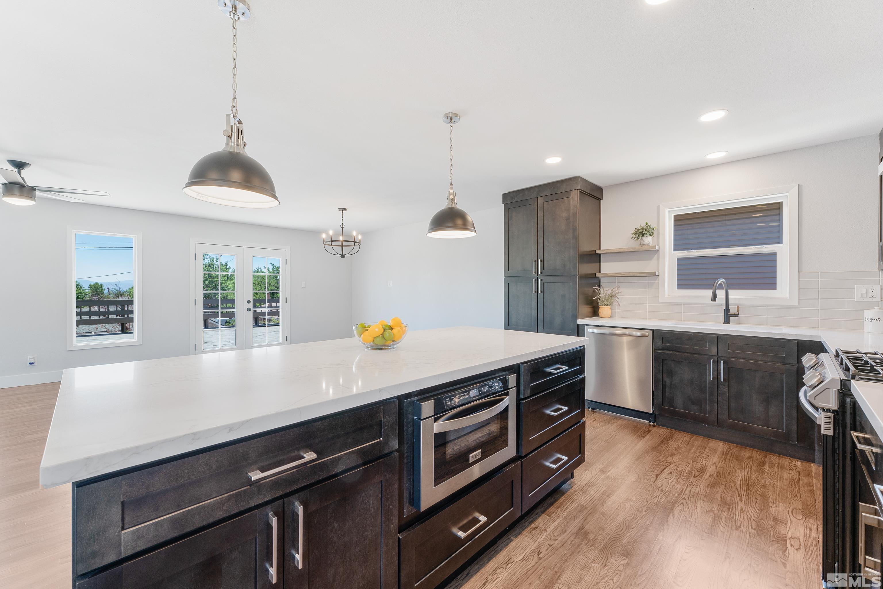3380 Bryan Street Reno, NV 89503 - Photo 21 of 40 a kitchen with stainless steel appliances a sink stove and wooden cabinets
