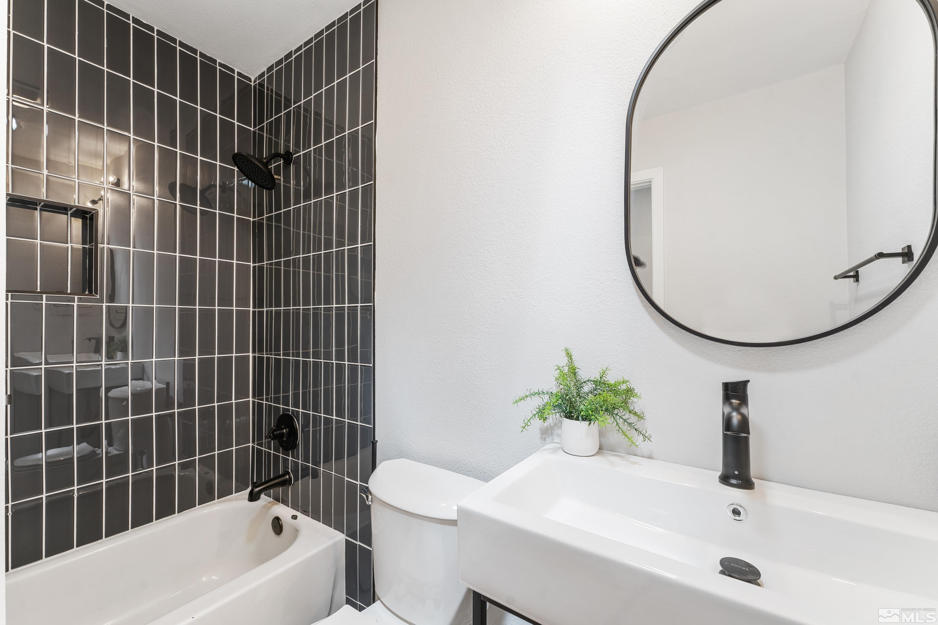 3380 Bryan Street Reno, NV 89503 - Photo 25 of 40 a bathroom with a bathtub a sink a toilet and a mirror