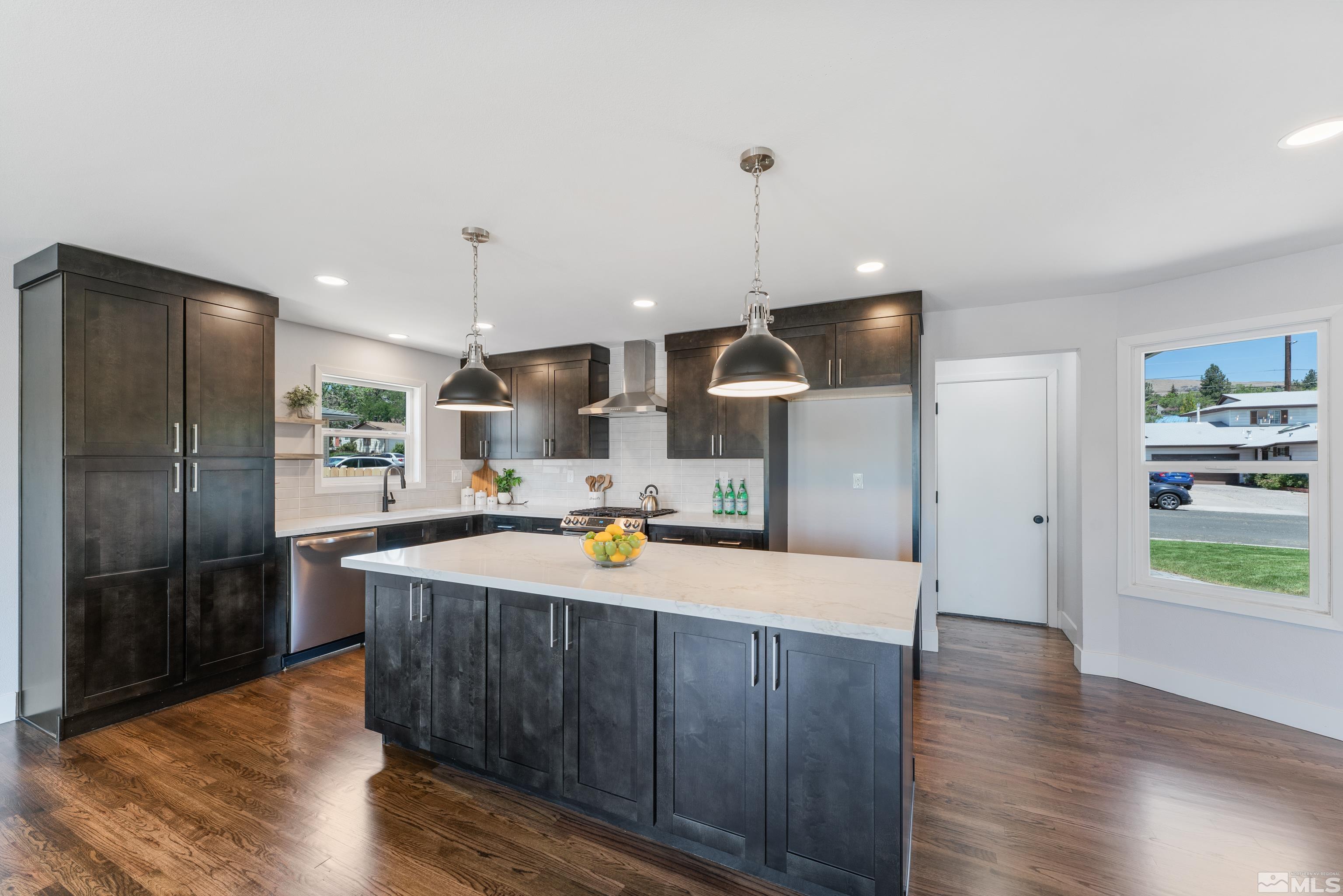 3380 Bryan Street Reno, NV 89503 - Photo 3 of 40 a large kitchen with stainless steel appliances kitchen island granite countertop a refrigerator a oven and a wooden floors