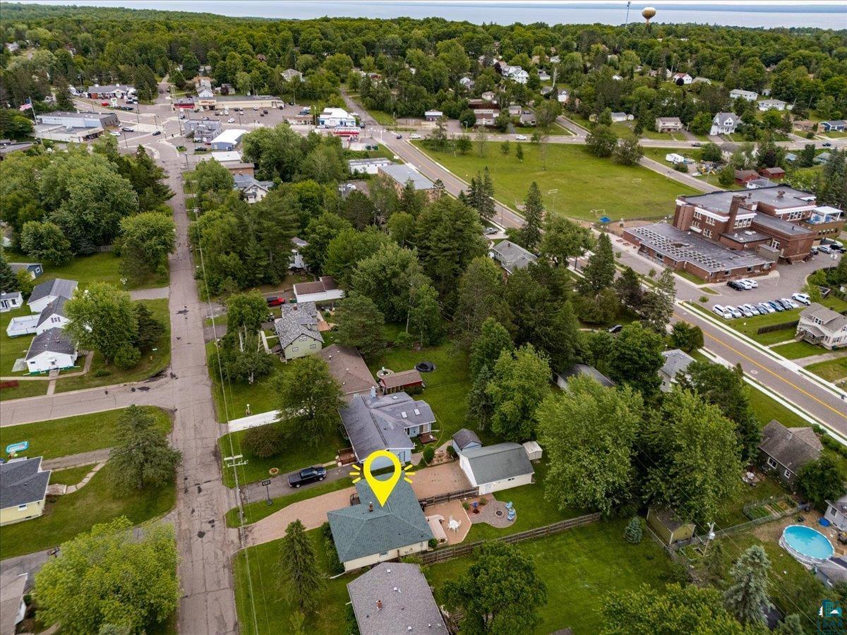 130 West Austin Street Duluth, MN 55803 - Photo 35 of 35 Aerial perspective showcasing a residential property with a green shingle roof, accompanied by a paved driveway and a patio area