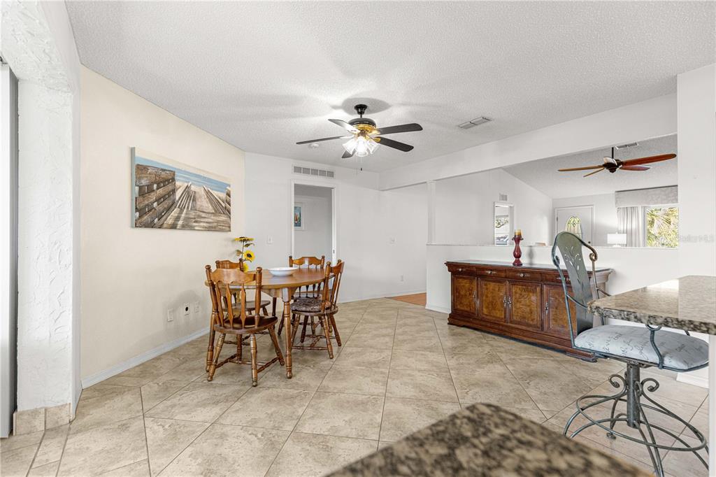 8962 Southwest 97th Street, Unit D Ocala, FL 34481 - Photo 11 of 56 a view of a dining room and kitchen with furniture and a chandelier fan