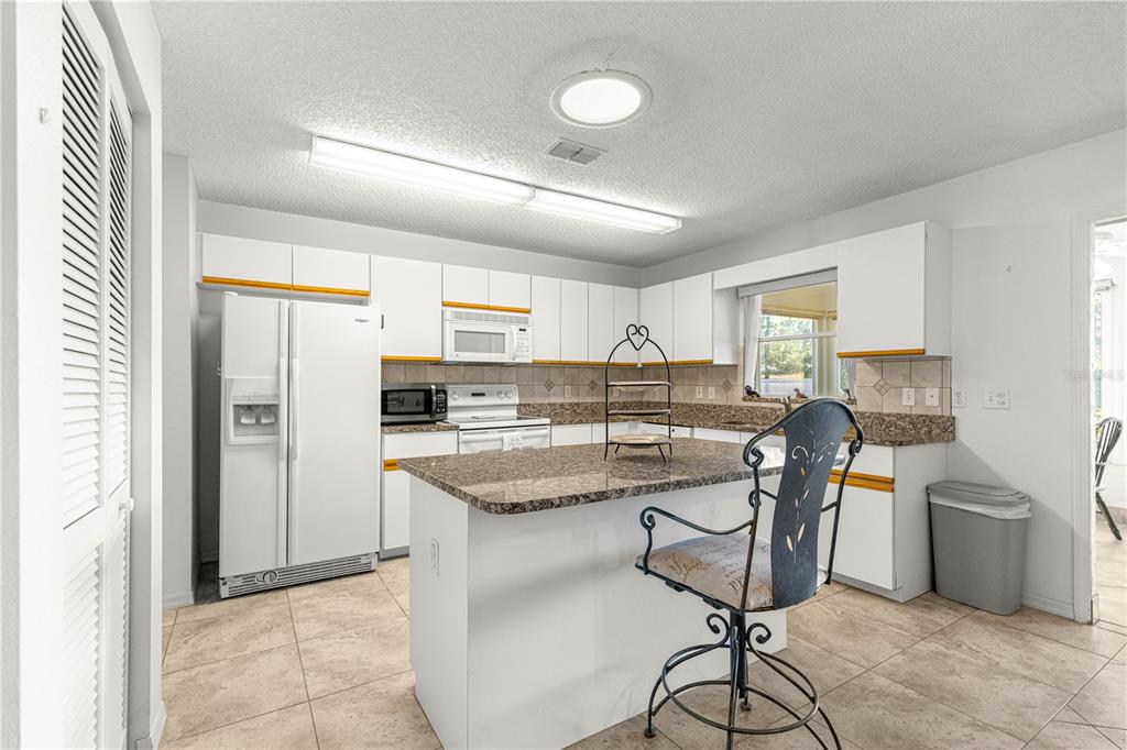 8962 Southwest 97th Street, Unit D Ocala, FL 34481 - Photo 14 of 56 a kitchen with stainless steel appliances granite countertop a refrigerator and a stove top oven
