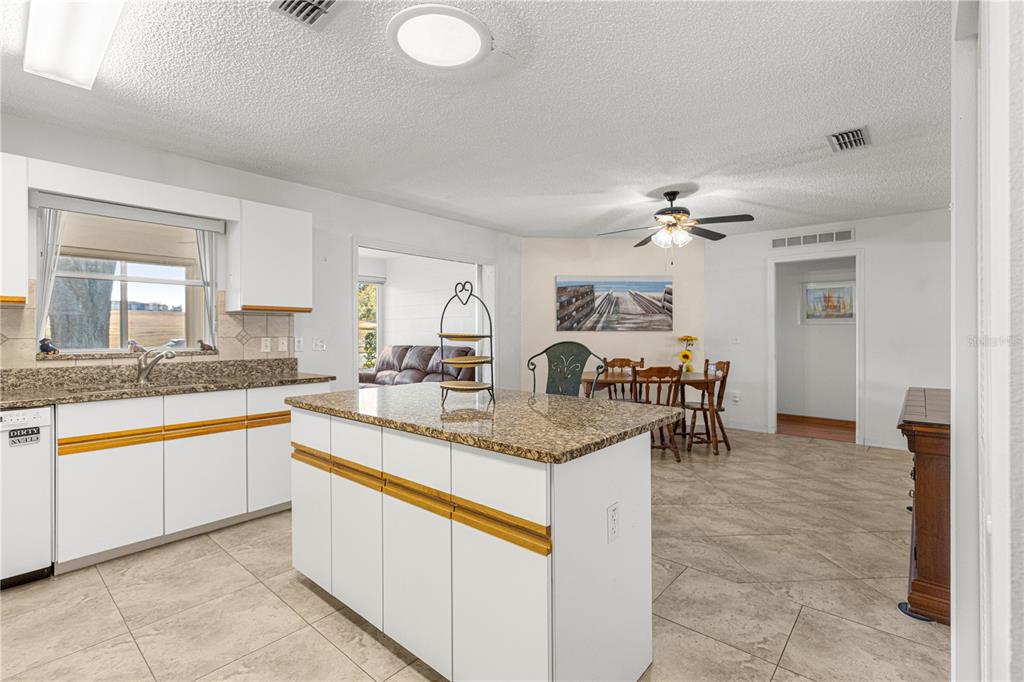 8962 Southwest 97th Street, Unit D Ocala, FL 34481 - Photo 15 of 56 a large kitchen with granite countertop a sink and white cabinets