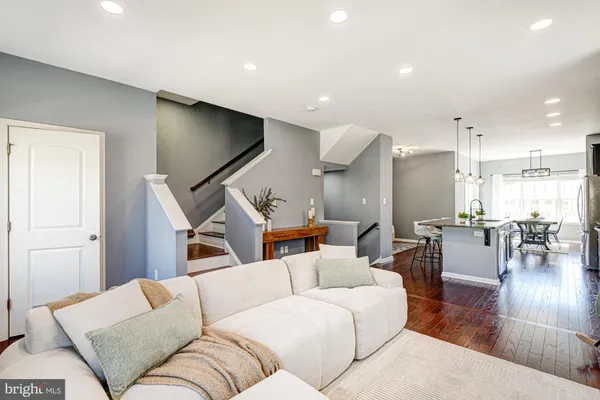 a kitchen with stainless steel appliances granite countertop a stove top oven a refrigerator a sink and a dining table with wooden floor