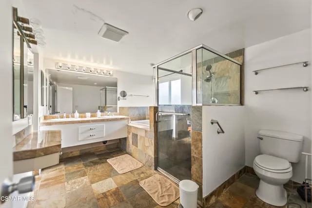 a bathroom with a double vanity sink mirror and shower