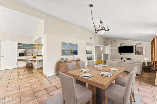 a kitchen with a stove a sink dishwasher a dining table and chairs with wooden floor