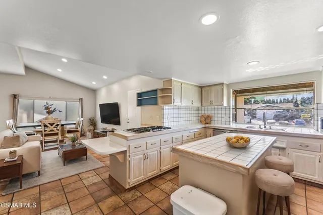 a kitchen with a stove a sink a counter top space and cabinets