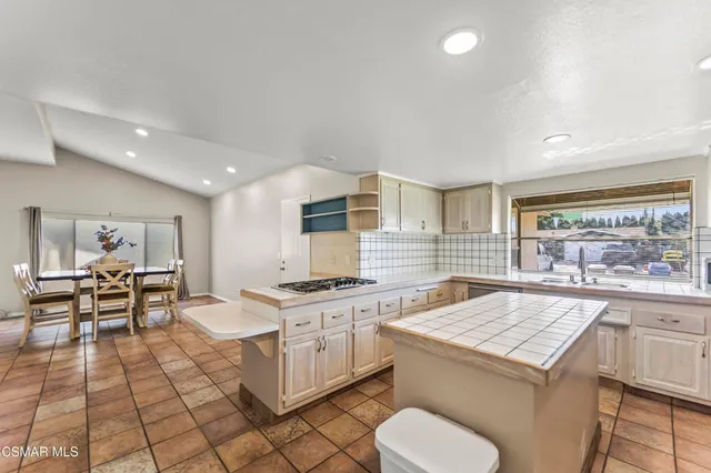 a kitchen with a stove a refrigerator and cabinets