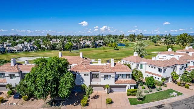 an aerial view of a house with a garden and lake view