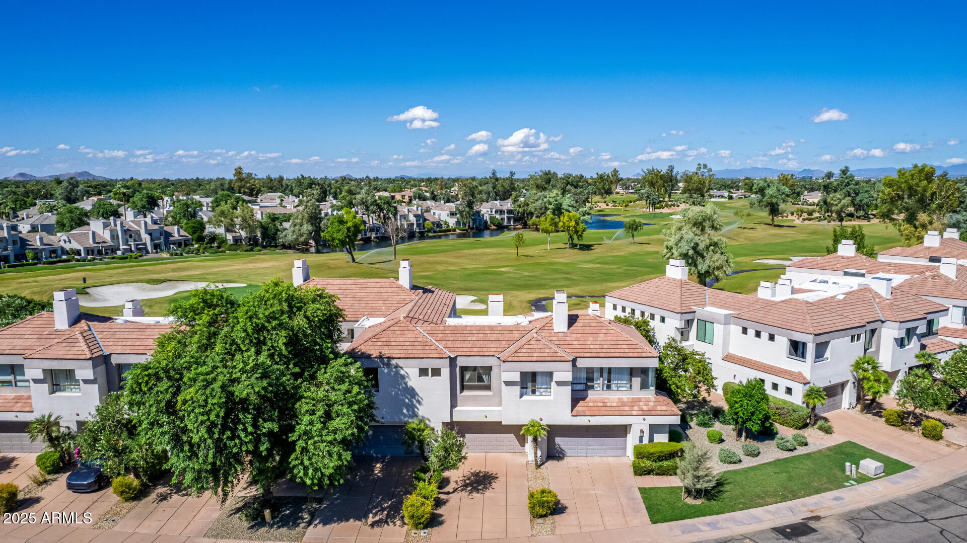 an aerial view of a house with a garden and lake view