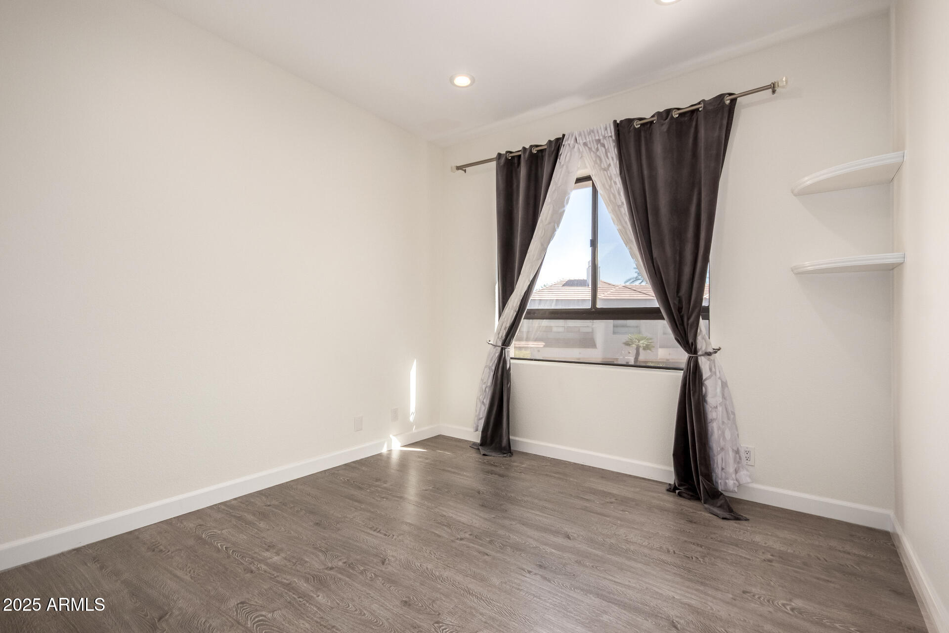 7222 East Gainey Ranch Road, Unit 241 Scottsdale, AZ 85258 - Photo 11 of 74 an empty room with wooden floor and window