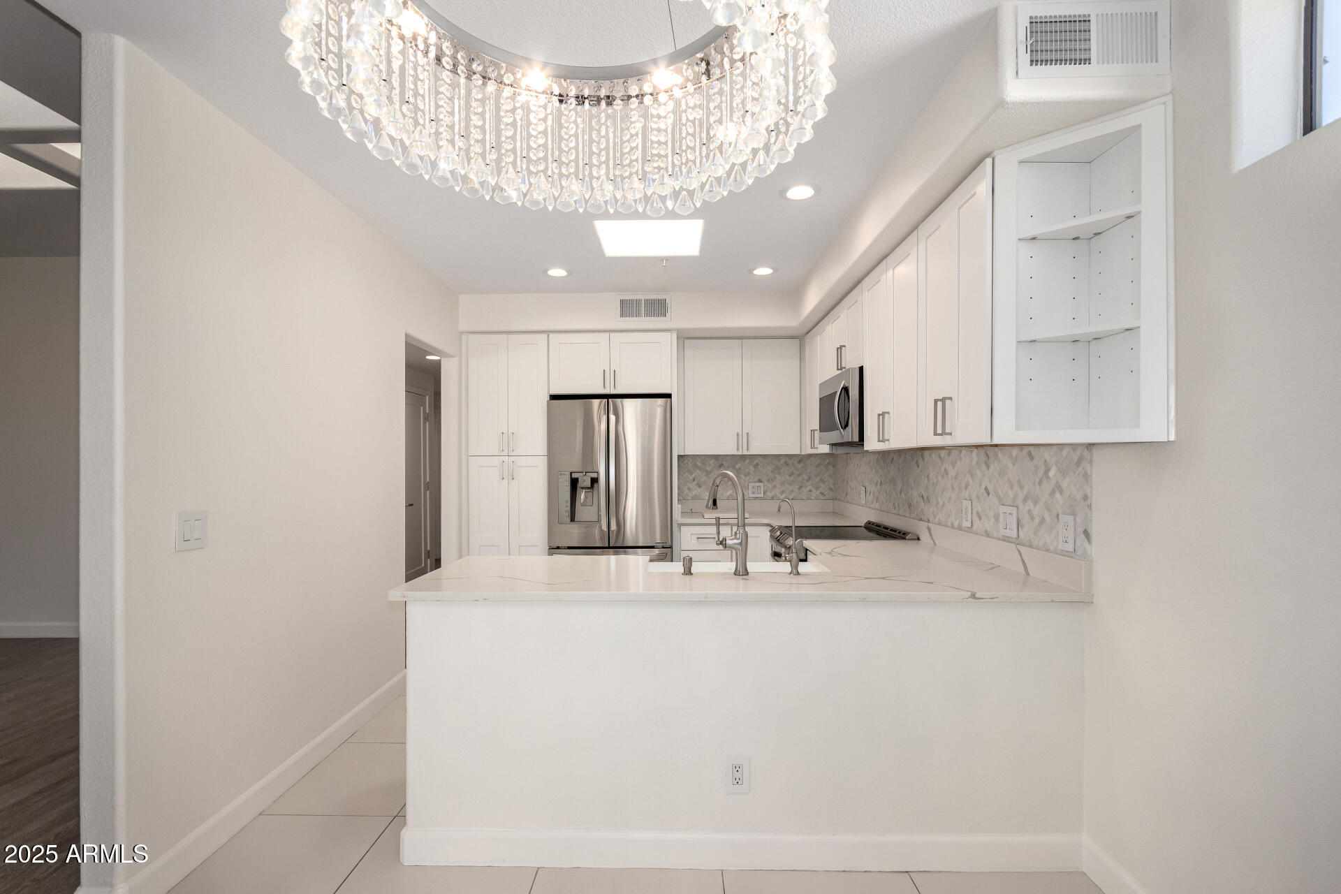 7222 East Gainey Ranch Road, Unit 241 Scottsdale, AZ 85258 - Photo 2 of 74 a view of a kitchen with a sink and chandelier