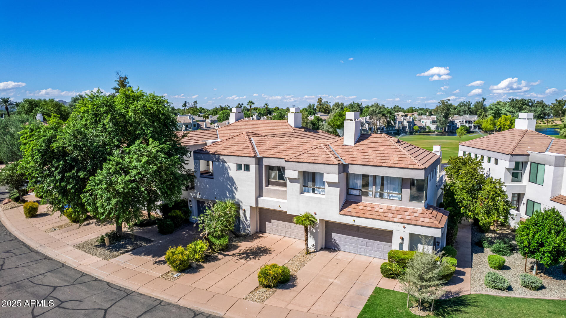 7222 East Gainey Ranch Road, Unit 241 Scottsdale, AZ 85258 - Photo 49 of 74 a front view of a house with a yard and potted plants