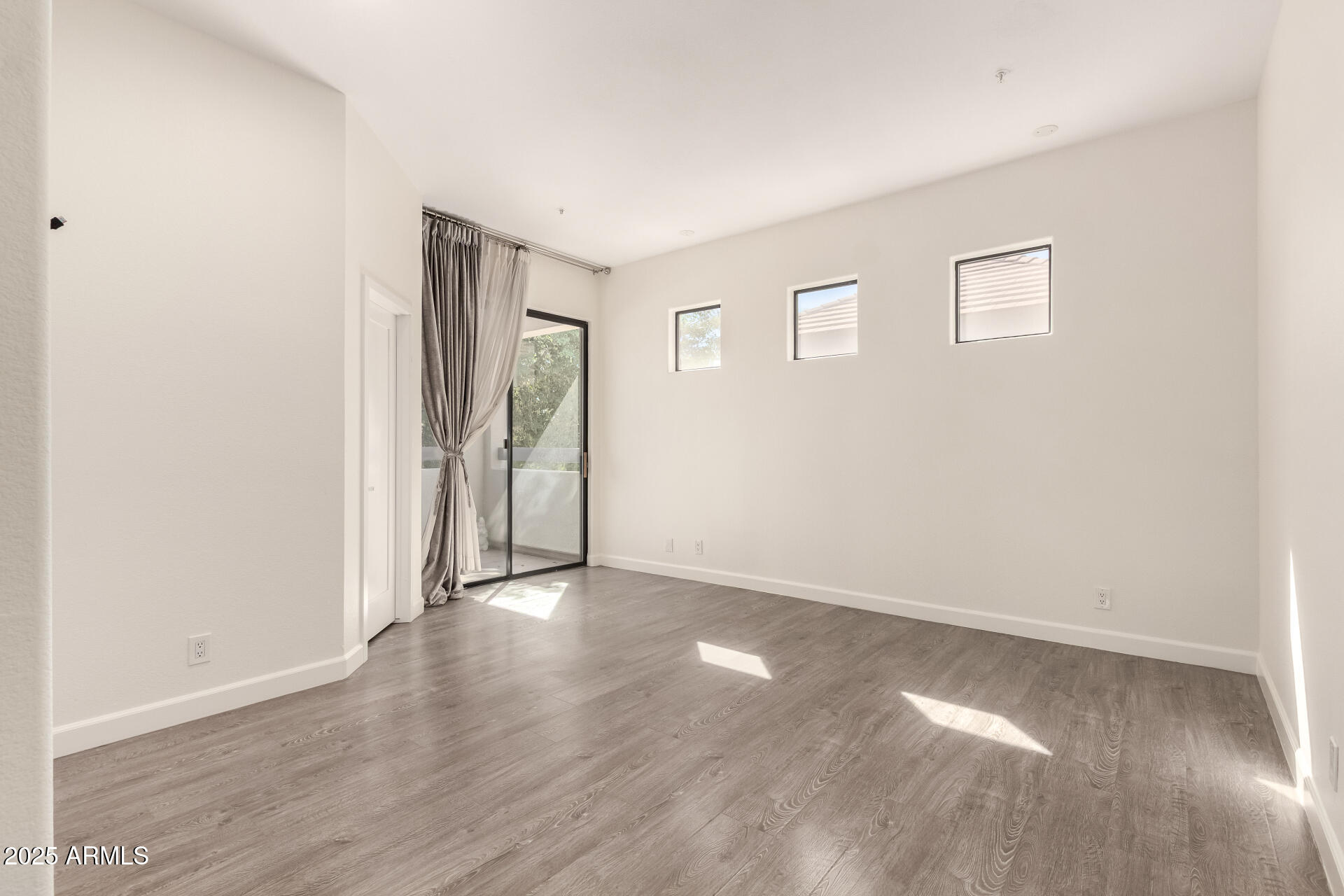 7222 East Gainey Ranch Road, Unit 241 Scottsdale, AZ 85258 - Photo 65 of 74 an empty room with wooden floor and windows