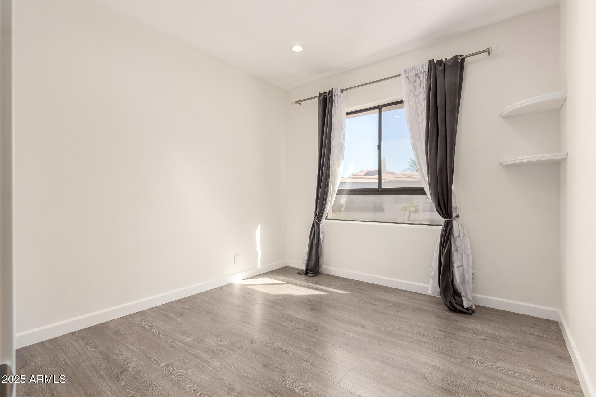 7222 East Gainey Ranch Road, Unit 241 Scottsdale, AZ 85258 - Photo 69 of 74 a view of an empty room with wooden floor and a window