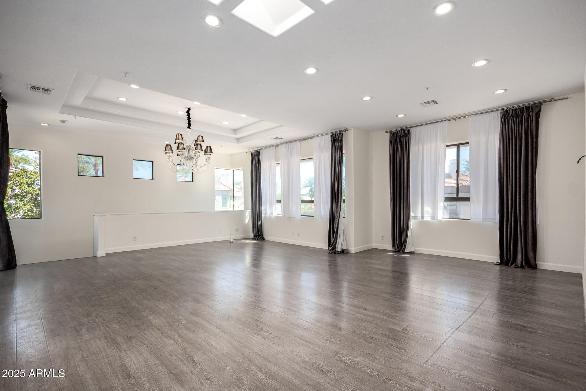 7222 East Gainey Ranch Road, Unit 241 Scottsdale, AZ 85258 - Photo 7 of 74 a view of an empty room with wooden floor and a kitchen