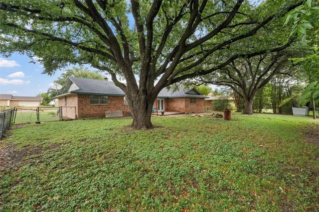 a view of a house with yard and tree s