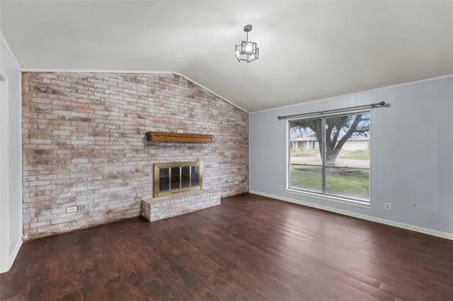 a view of empty room with wooden floor and fireplace