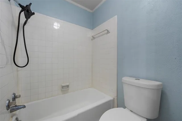 a bathroom with a toilet and a bath tub