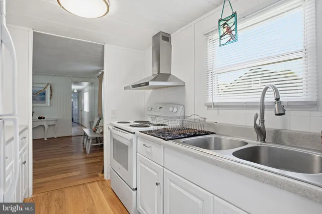 a kitchen with granite countertop a sink stainless steel appliances and cabinets