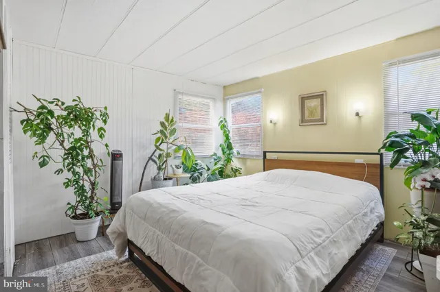 a bedroom with a bed and a potted plant