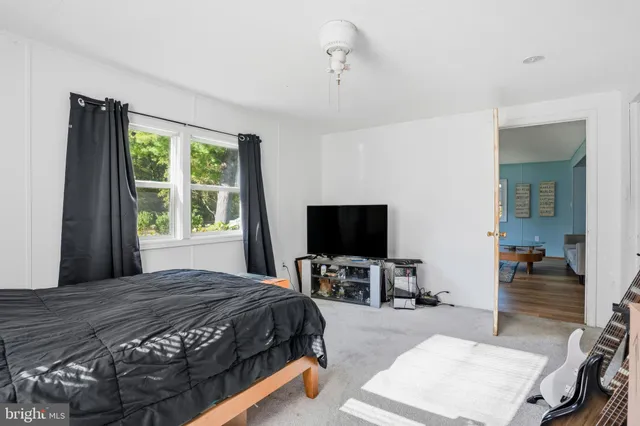 a bedroom with a bed and a flat tv screen on dresser