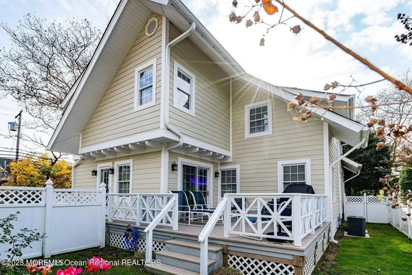 a view of a white house with a small yard and furniture