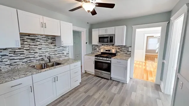 a kitchen with stainless steel appliances white cabinets and a stove