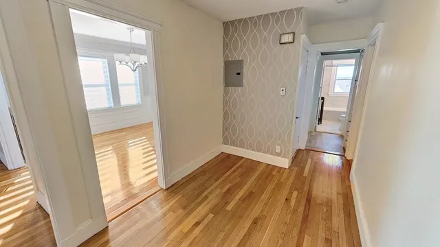 a view of empty room with wooden floor and fan