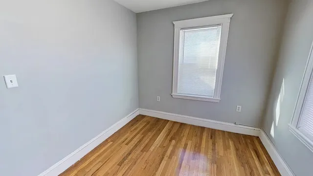 a view of a room with wooden floor and small window