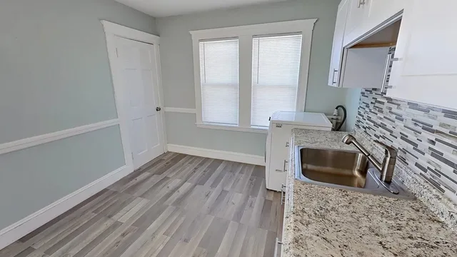 a kitchen with granite countertop a stove a sink and a microwave