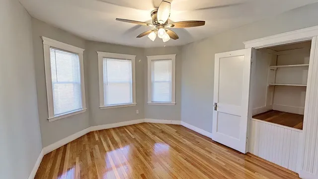 a view of empty room with a ceiling fan and window