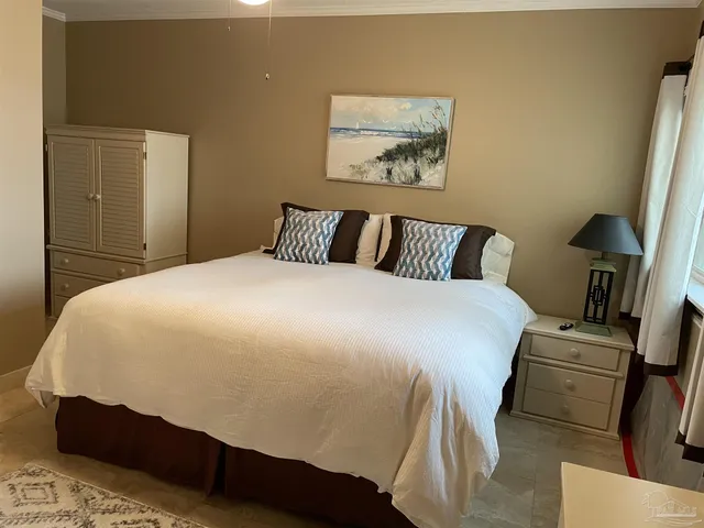a bedroom with a bed and painting on the wall