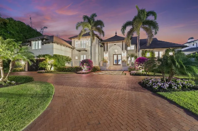 a front view of a house with a yard and potted plants