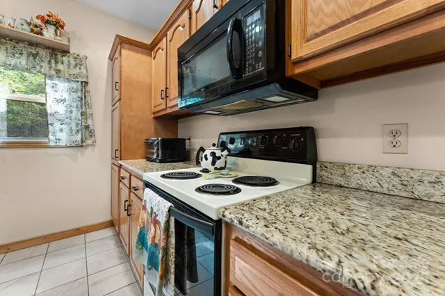 a kitchen with stainless steel appliances granite countertop a refrigerator a oven and a sink with granite countertops