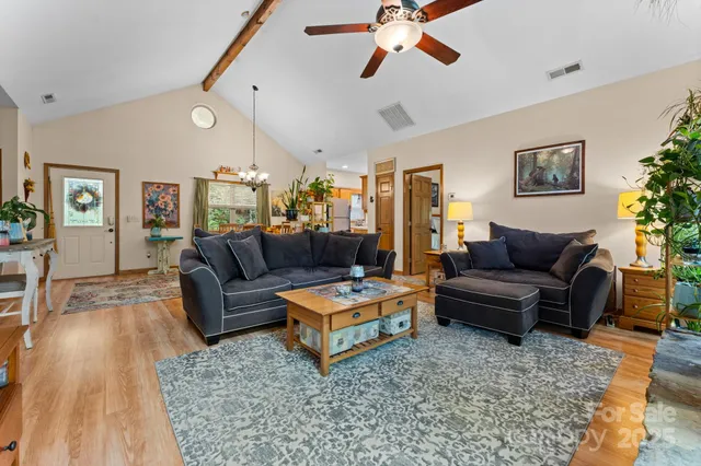 a living room with furniture a chandelier and a dining table