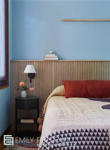 a bedroom with a bed and a lamp on dresser