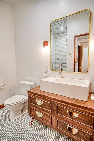 a bathroom with a sink a toilet and mirror