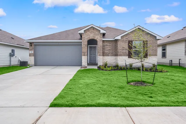 a front view of a house with a garden and plants