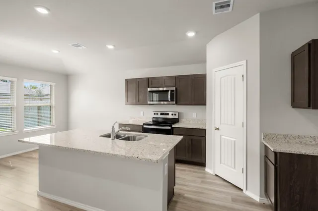 a kitchen with stainless steel appliances granite countertop a sink stove and refrigerator