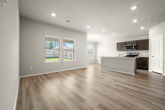 a view of kitchen with microwave a stove and wooden floor
