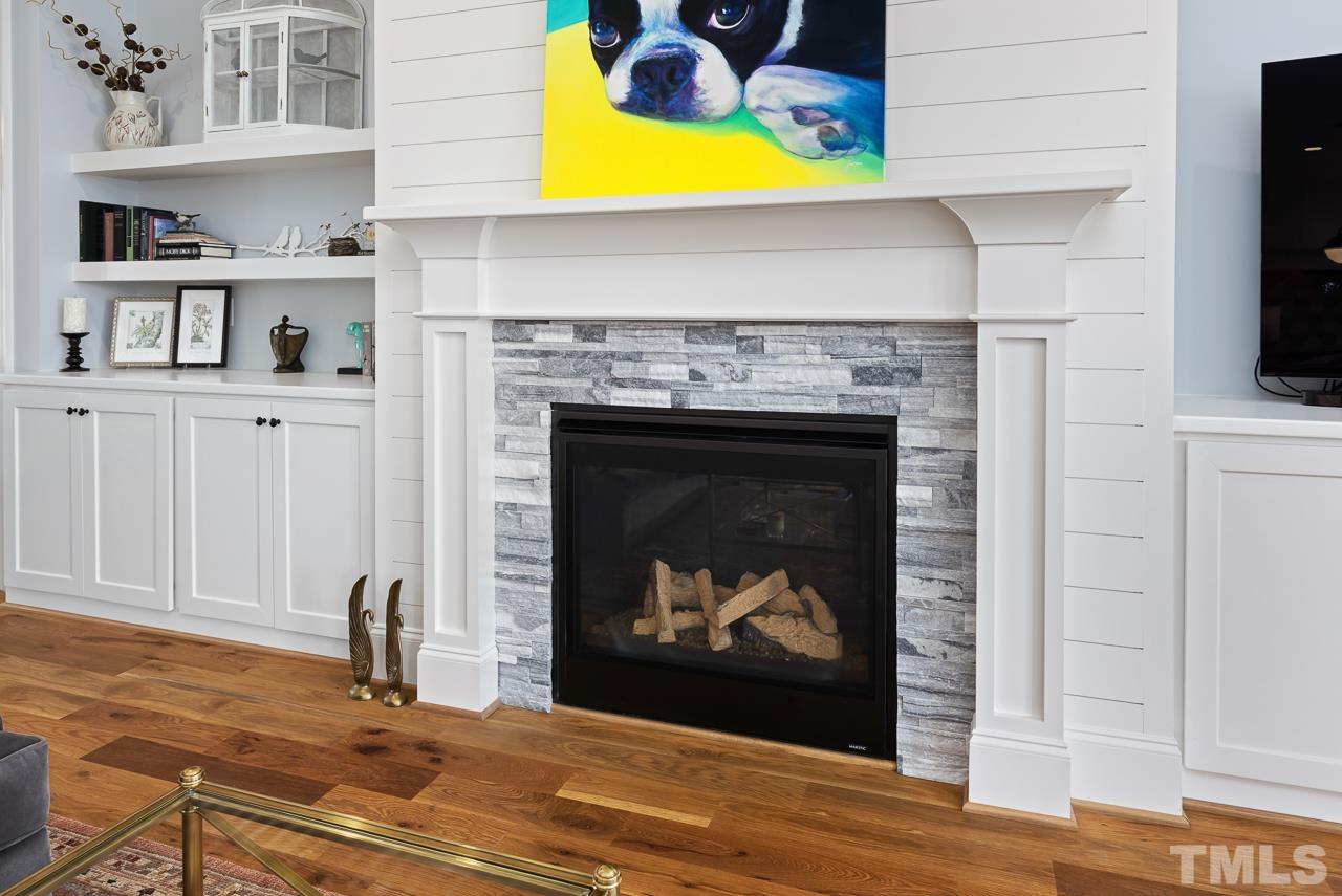 1709 Montvale Grant Way Apex, NC 27523 - Photo 14 of 68 a living room with a fireplace and a flat screen tv