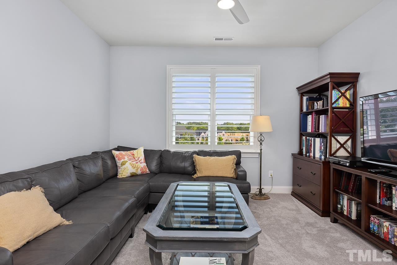 1709 Montvale Grant Way Apex, NC 27523 - Photo 39 of 68 a living room with furniture a book shelf and a window
